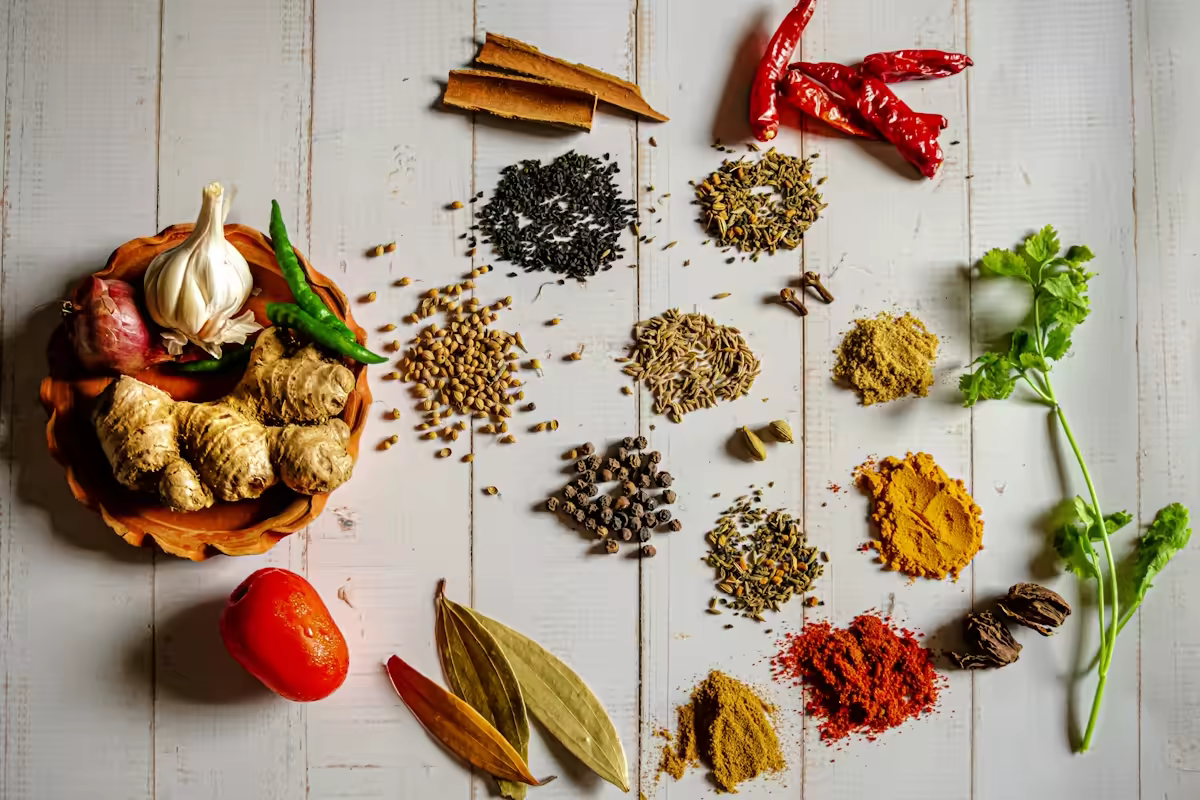 Assorted authentic Indian spices including turmeric, star anise, chili, and cumin